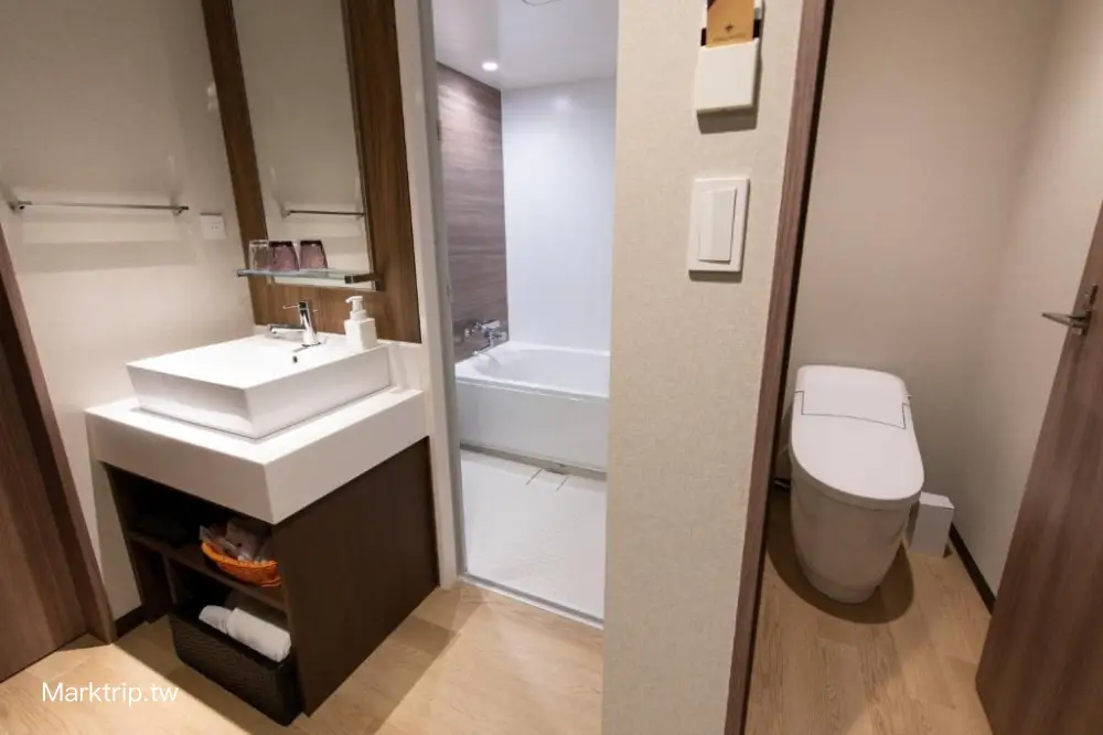 飯店衛浴空間，展現浴廁分離設計（洗手台、浴缸、獨立馬桶間）。